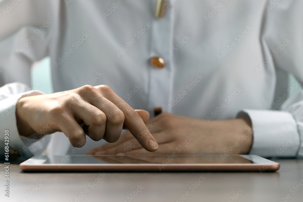 Closeup view of woman using modern tablet at table Closeup view of woman using modern tablet at table