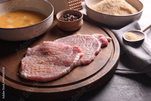 Cooking schnitzel. Raw pork slices and other ingredients on grey table, closeup