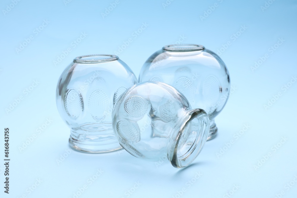 Glass cups on light blue background. Cupping therapy Glass cups on light blue background. Cupping therapy