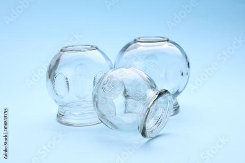 Glass cups on light blue background. Cupping therapy