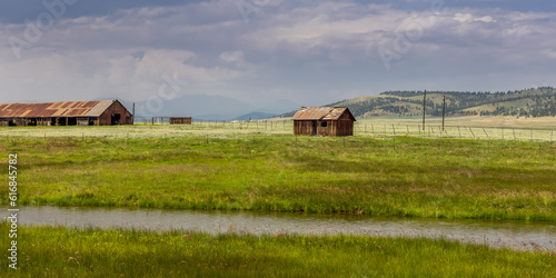 Panoramic view of abandoned barns in the middle of Prairie landscape of Colorado.