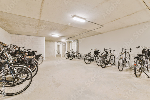 several bikes parked in a room with white walls and concrete flooring on the wall, there is an empty space for them to