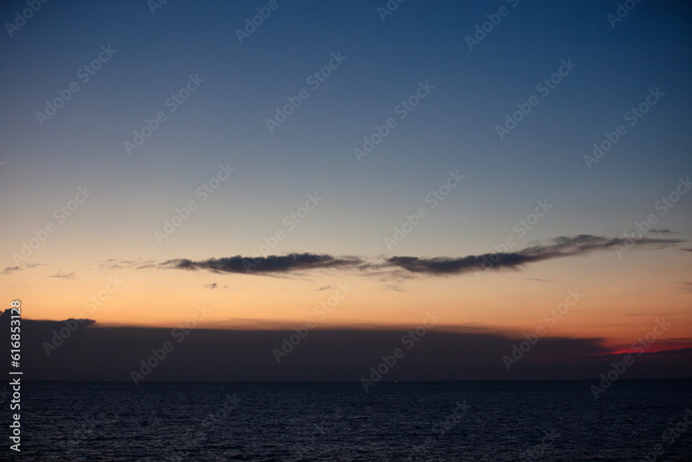 Fototapeta premium The sky and the sea in the evening near the sun will set. The golden yellow light against the water was a beautiful moment. sometimes saw mountain shadows interspersed