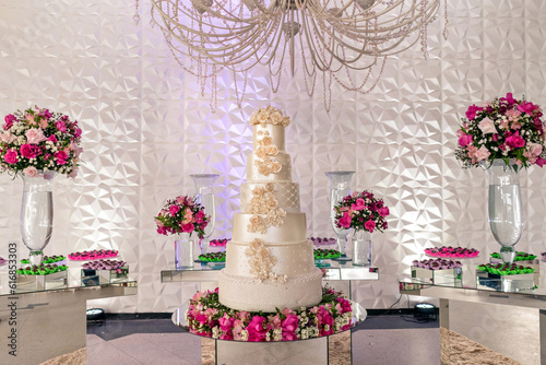 a wedding cake and trays of chocolate brigadeiro on top of a glass table