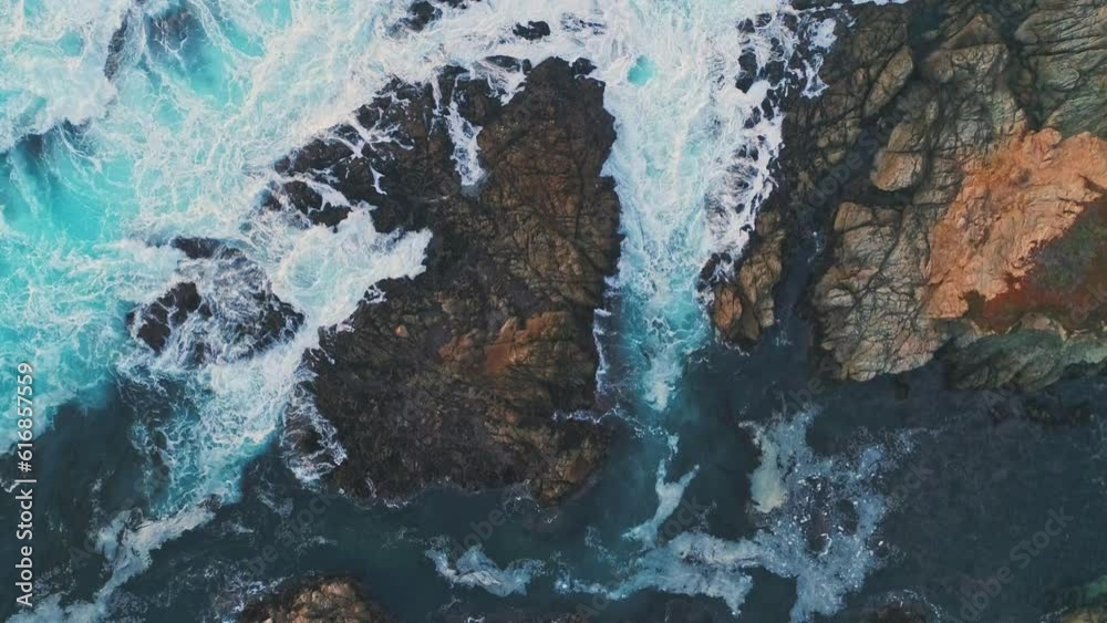 Top down view of ocean waves crashing on rocks in Big Sur, California