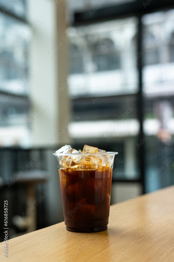 Iced coffee in glass on table in coffee shop blur background. Iced coffee in glass on table in coffee shop blur background.