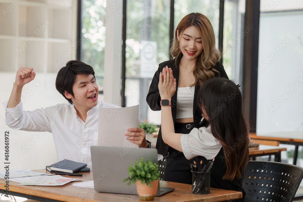 Team of professionals celebrating success at meeting room. giving each other a high five. business finance, teamwork
