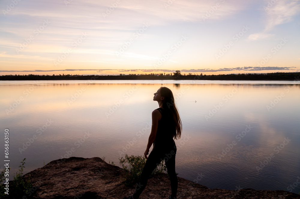 Fototapeta premium Traveler woman walking by the lake during sunset.