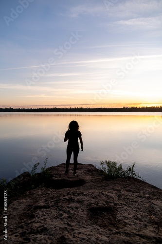 Traveler woman walking by the lake during sunset.