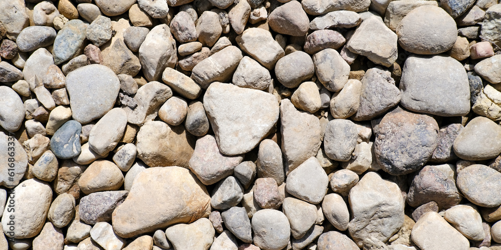 Abstract background with brown and beige dry stones, cobblestones, gravel. Gravel texture or background for design, for banner. Real grunge background texture and small stone. Close up, top view. Abstract background with brown and beige dry stones, cobblestones, gravel. Gravel texture or background for design, for banner. Real grunge background texture and small stone. Close up, top view.