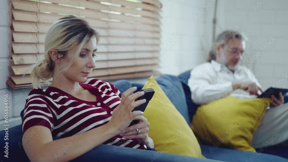 Senior father and daugther sitting on sofa and using laptop, mobile phone and digital tablet. Senior father and daugther sitting on sofa and using laptop, mobile phone and digital tablet.