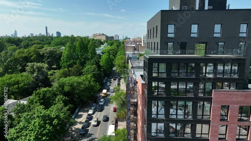 Aerial truck shot of modern apartment building revealing Prospect Park in Brooklyn, New York. Beautiful summer establishing shot in NYC.
