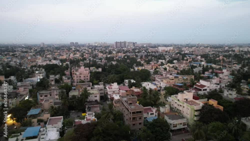 An aerial view of Chennai City reveals a crowded neighborhood, high-rise structures, and metro rail construction. An aerial view of Chennai City reveals a crowded neighborhood, high-rise structures, and metro rail construction.