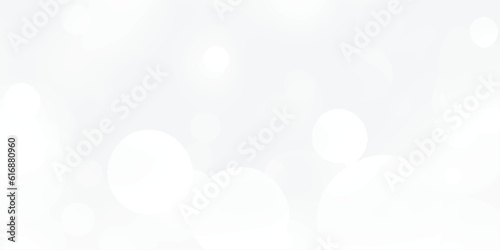 Abstract silver bokeh background with white light at center. The bokeh on the white background blurred the natural gray and white. Bokeh colorful glows sparkle.