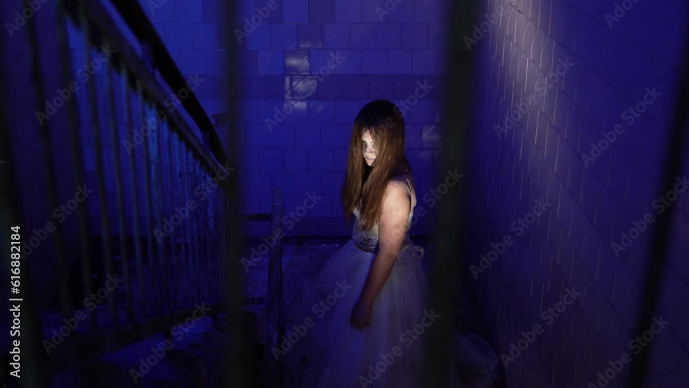 Zombie female dressed in a wedding dress walk on stairs in old abandoned house Zombie female dressed in a wedding dress walk on stairs in old abandoned house