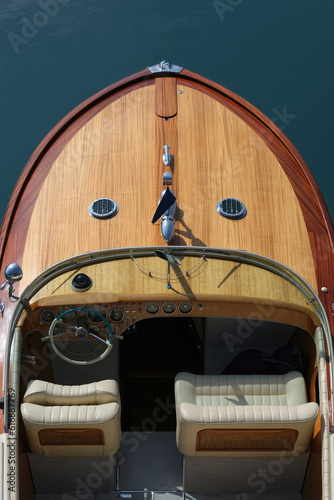 Wooden deck on a blue background top view. Boat with white leather chair. Helm boat. The front of a wooden boat on a blue background top view. Expensive wooden lacquered part of the boat. Fore deck