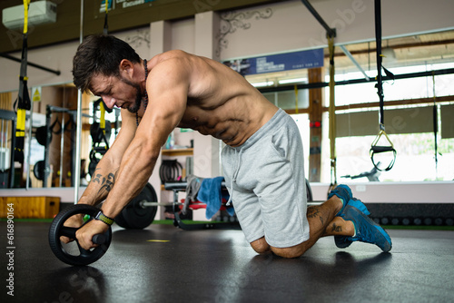 Tired Man using the ab wheel in a gym photo