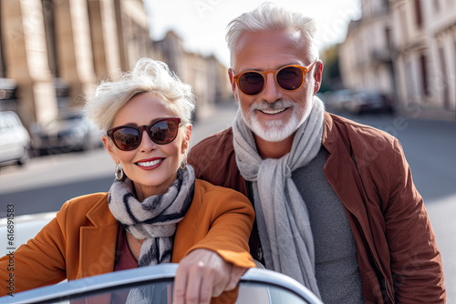 Sexy senior couple posing with cabrio car on background