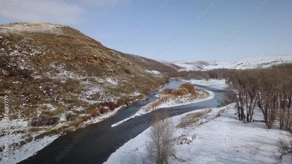 Aerial Panning Shot Of People With Horse On Snow By River, Drone Descending Over Natural Landscape Against Sky - Billings, Montana Aerial Panning Shot Of People With Horse On Snow By River, Drone Descending Over Natural Landscape Against Sky - Billings, Montana