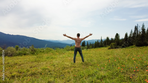 Aerial view of man doing yoga on mountain landscape.
