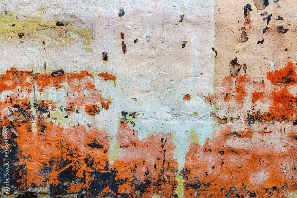 Old worn wall with paint peeling off the surface as grunge background and texture