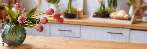 Vase with pink tulips in a modern kitchen. Home concept with spring flowers. Banner for website header design with copy space.