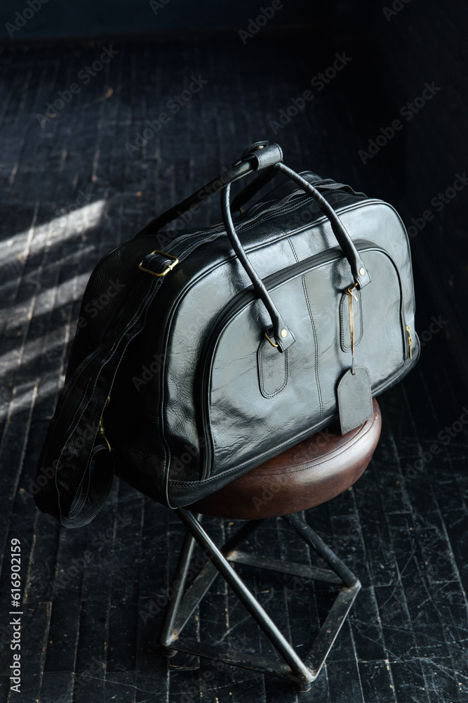 black leather travel bag indoors photo on black background black leather travel bag indoors photo on black background