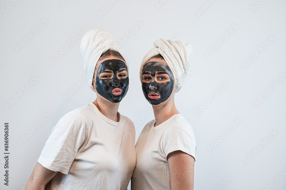 Portrait of two sister or girlfriend make skin facial mask isolated on white Portrait of two sister or girlfriend make skin facial mask isolated on white
