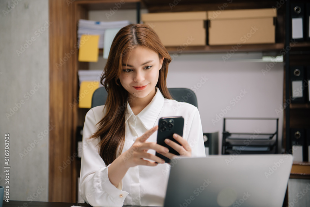 Young attractive Asian woman smiling thinking planning writing in notebook, tablet and laptop working from home at office .