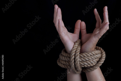 Woman with hands tied with rope, concept of violence, woman's rights