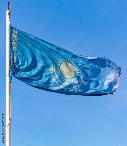 Flag of the Republic of Kazakhstan waving in the wind against the blue sky