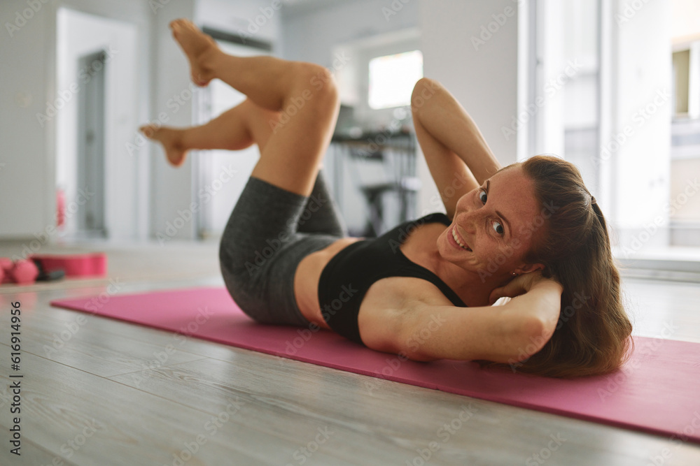 Happy young woman practicing exercise on mat Happy young woman practicing exercise on mat