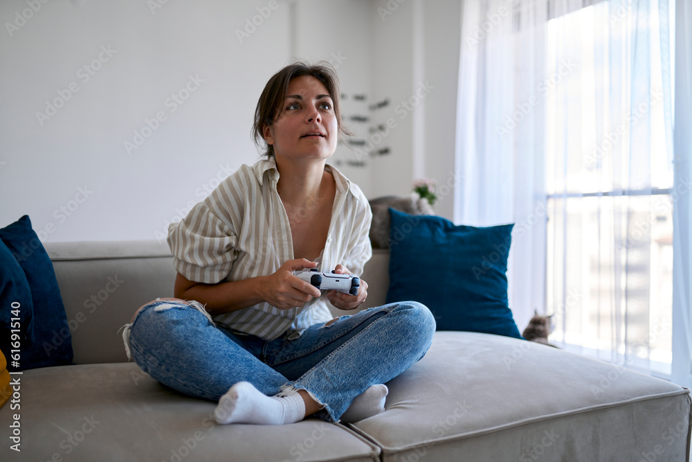 Woman with remote control playing video game at home Woman with remote control playing video game at home