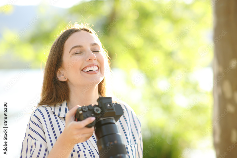 Happy photographer breathing fresh air in nature