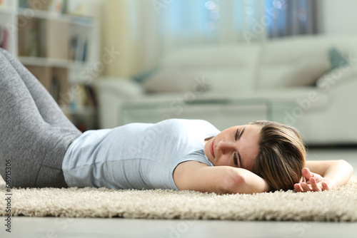Sad woman lying discouraged at home