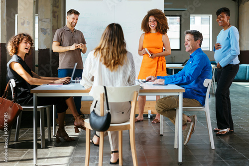 Happy business colleagues having discussion in meeting at office