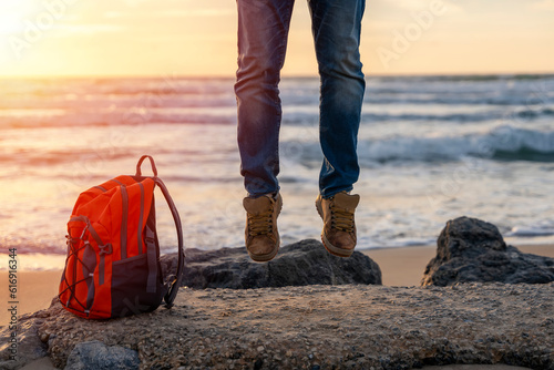 Happy Man jumping on the seaside on hot sunny day at sunset. Travel Lifestyle concept