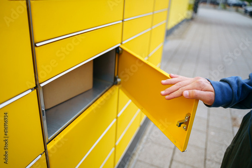 Hand of boy opening parcel locker photo