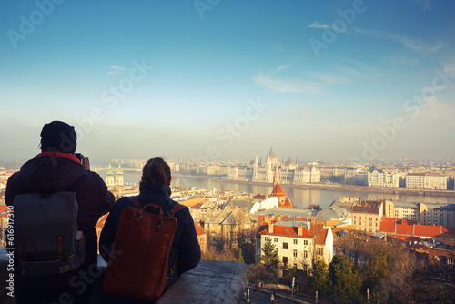 Two person looking at the city at sunset