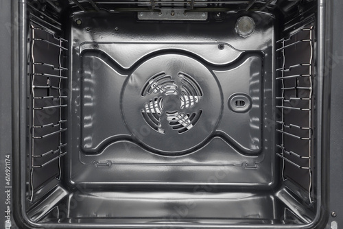 Inside of empty clean dark black new oven without trays. Front view. Closeup.