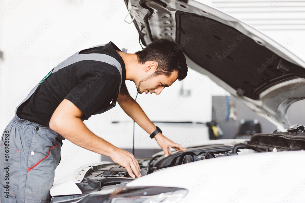 Car mechanic working in workshop checking engine Car mechanic working in workshop checking engine