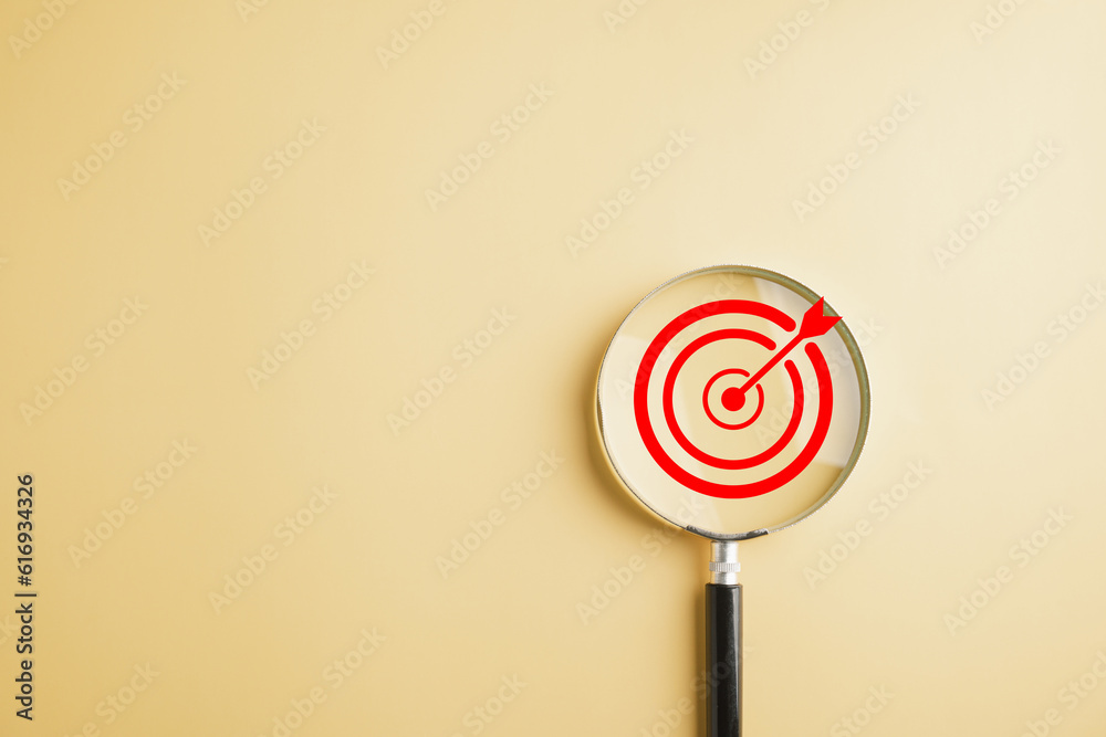 The magnifier glass focuses on target board, illustrating the importance of hitting business objectives. Against with copy space, it symbolizes efficiency, accuracy, and the pursuit of excellence. The magnifier glass focuses on target board, illustrating the importance of hitting business objectives. Against with copy space, it symbolizes efficiency, accuracy, and the pursuit of excellence.