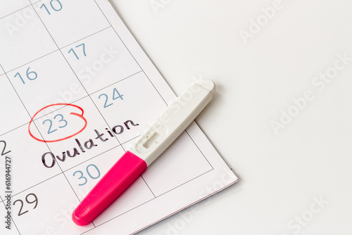 Pregnancy test with female ovulation day on calendar