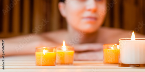 Candle with body therapy massage in the background. Health and body wellness concept. Skin relaxation and treatment. Sauna and regeneration. Healing salt lamp. Ai generative.