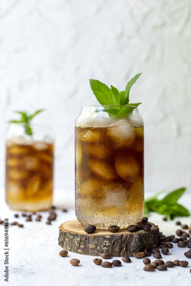 Cold summer cocktail with black coffee tonic mint and ice in glass on white background Cold summer cocktail with black coffee tonic mint and ice in glass on white background