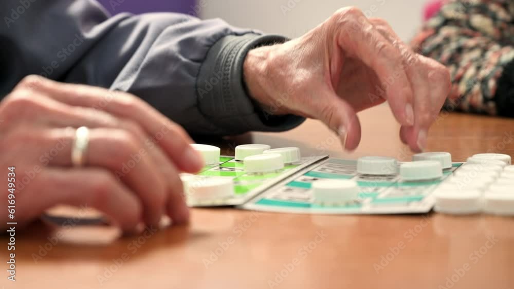 Close up of a senior man playing bingo at Nursing home. leisure game, support, assisted living, and retirement. High quality 4k footage Close up of a senior man playing bingo at Nursing home. leisure game, support, assisted living, and retirement. High quality 4k footage