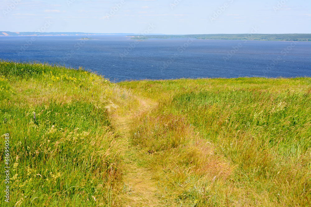 footpath on the hill with blue sea on background, copy space