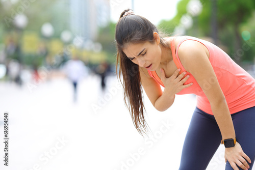 Exhausted runner touching chest in the street photo