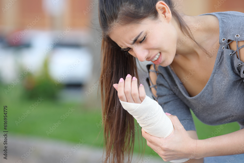 Woman suffering with bandaged sprained wrist Woman suffering with bandaged sprained wrist