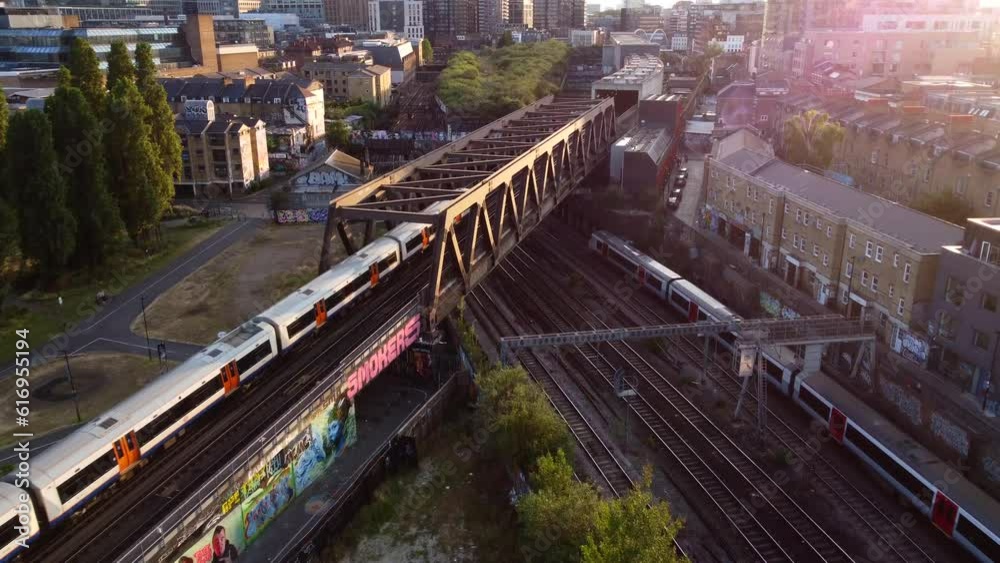 Drone shot overground train travelling through Shoreditch in London